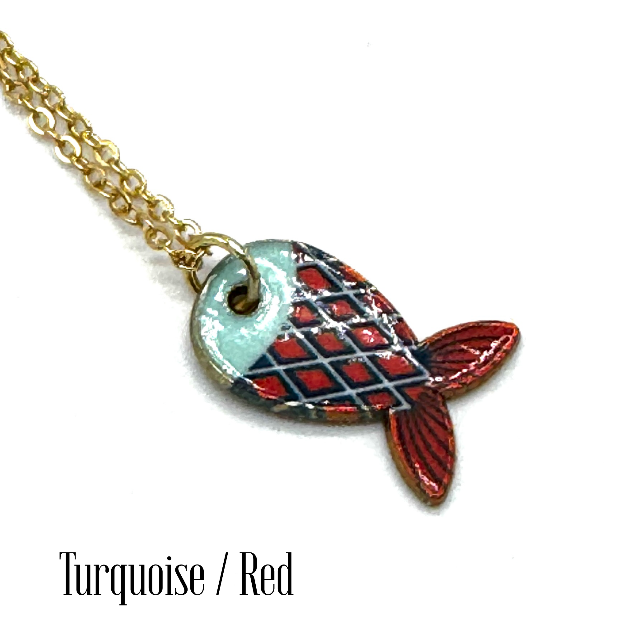 A gold chain necklace with a fish-shaped pendant featuring a turquoise and red plaid pattern, shown on a white background with the text &