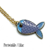 A gold chain necklace with a fish-shaped pendant featuring blue and lilac enamel scales, shown on a white background with the text &