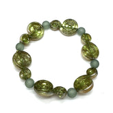 A beaded stretch bracelet featuring textured olive green spiral beads and matte sage green round beads, displayed on a clean white background.