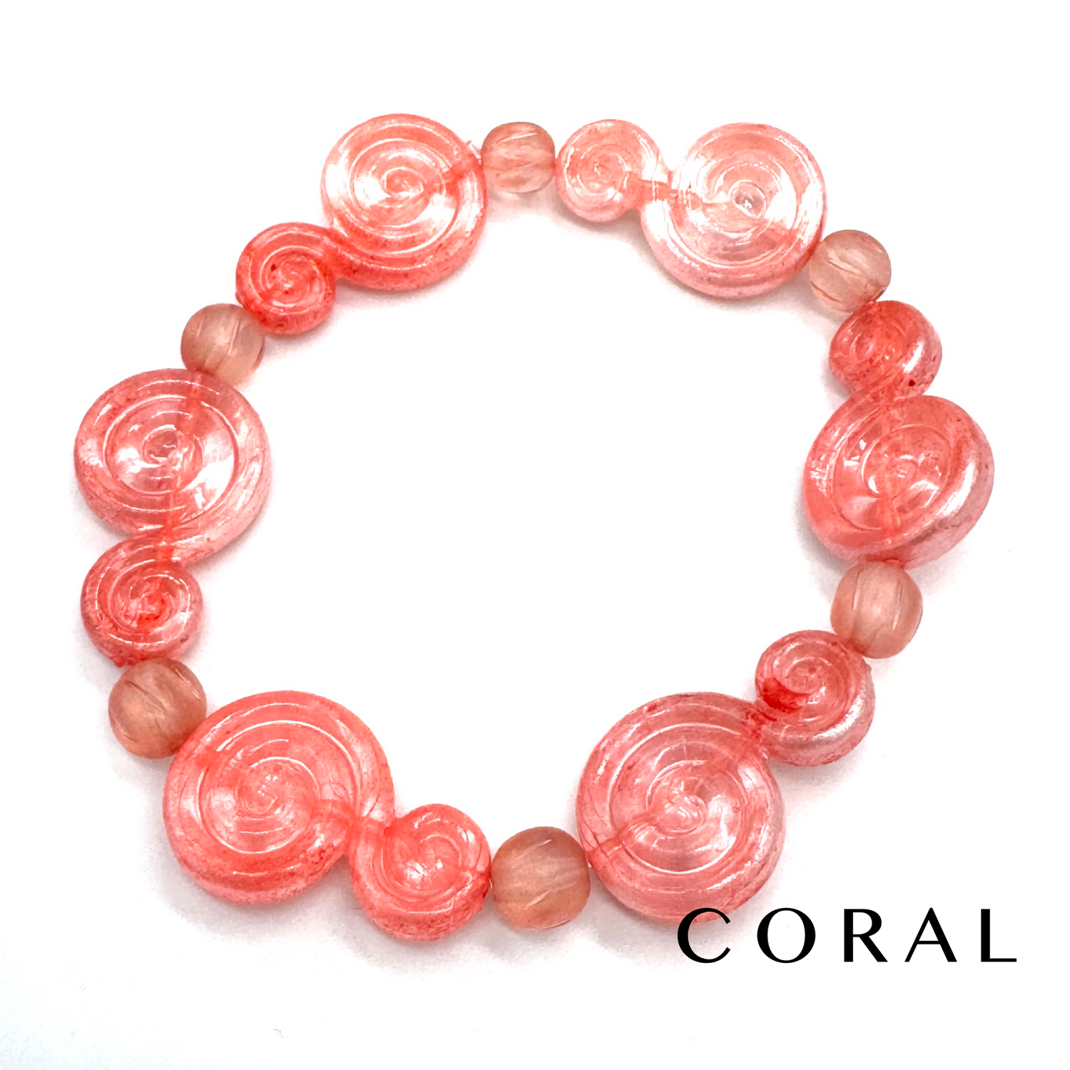A coral pink beaded bracelet featuring large spiral-shaped beads and smaller round beads, displayed on a clean white background with the word &