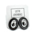 A pair of oval stud earrings with shiny silver-toned centers and dark textured outer borders, displayed on a white branded backing card that reads LEETIE LOVENDALE.