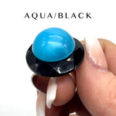 Ring with a blue lucite cabochon on a white background