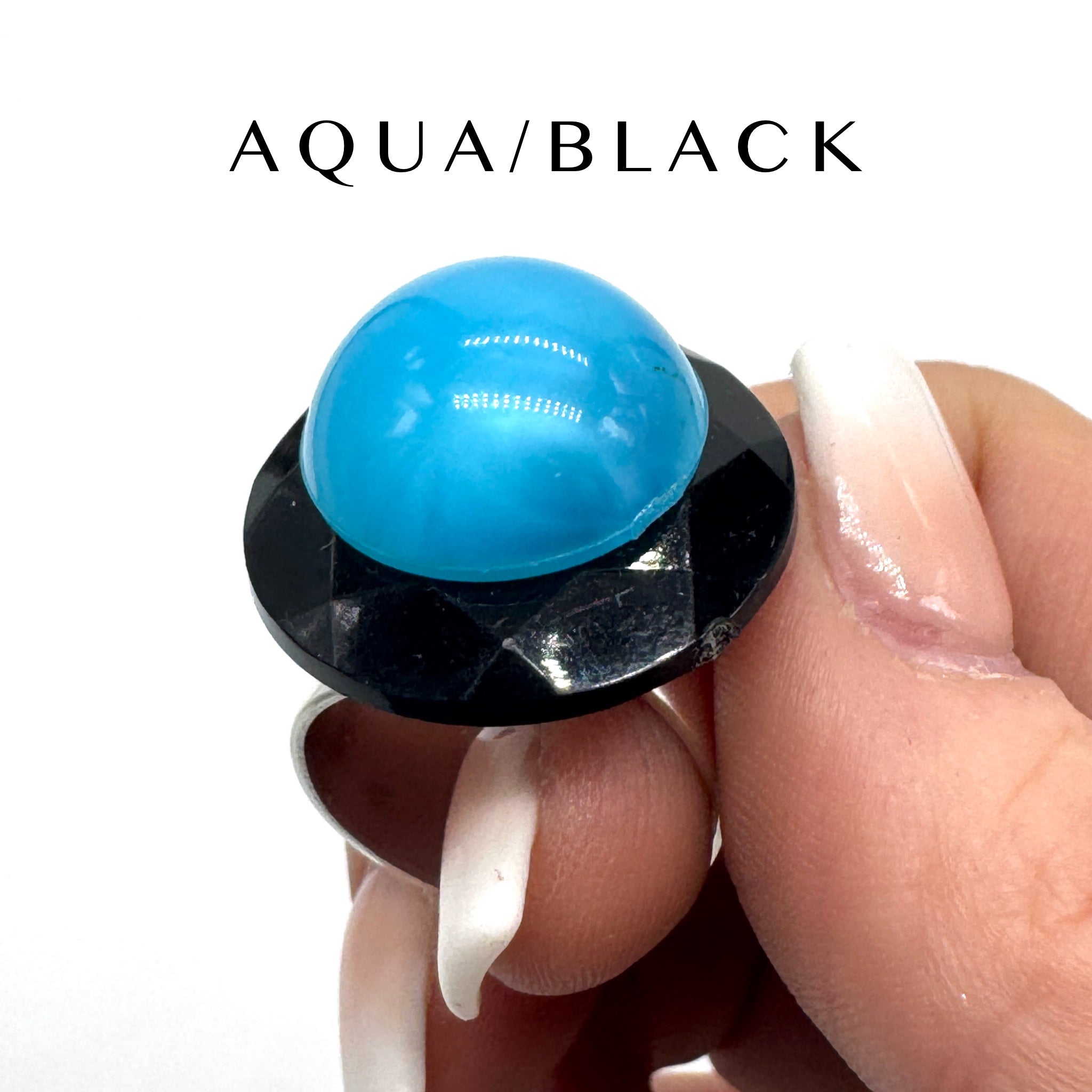 Ring with a blue lucite cabochon on a white background