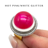 Hot pink and white glittery ring on a finger with text &