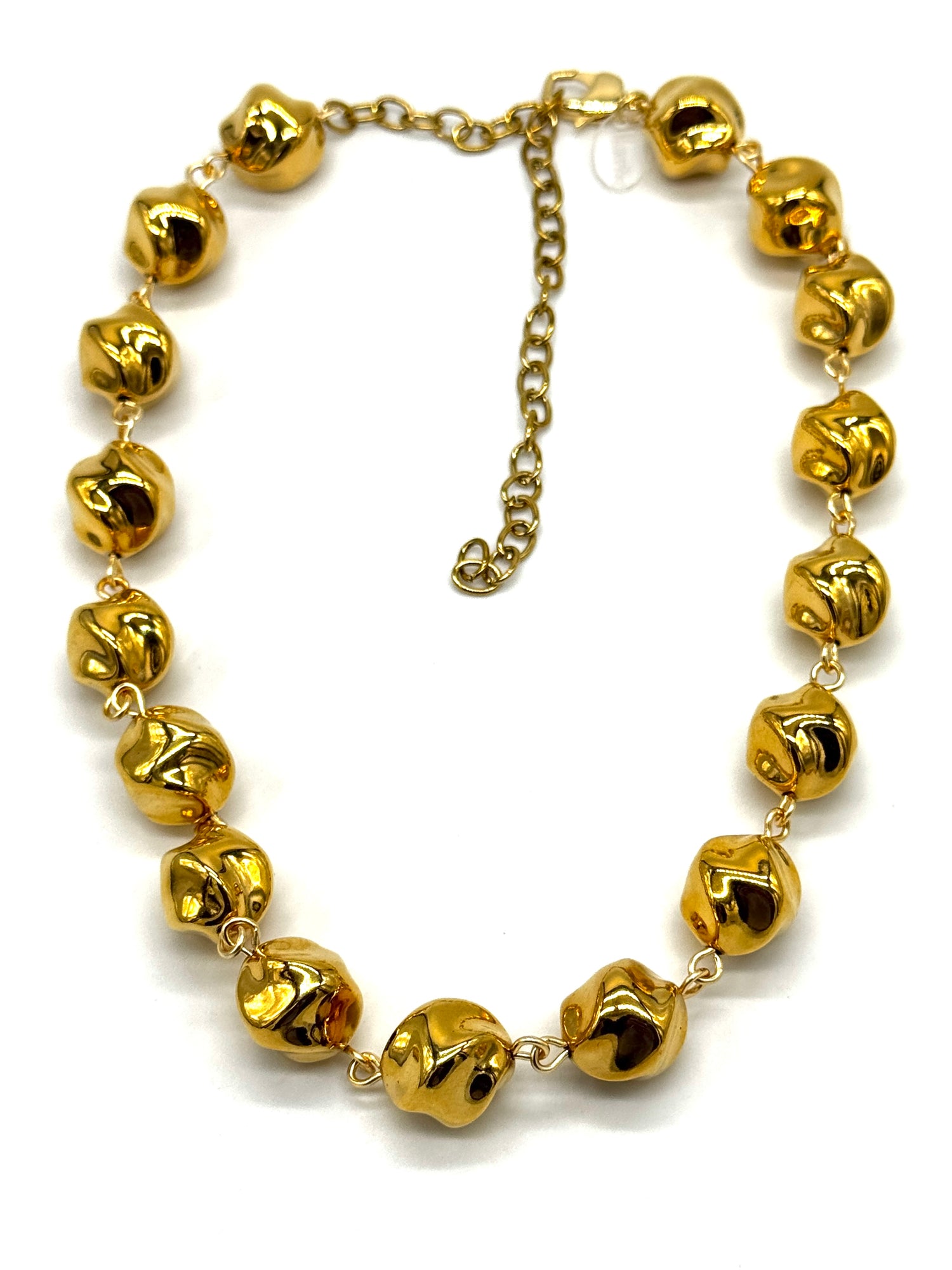 A gold-tone necklace featuring multiple small, shiny metallic beads linked by delicate chains, with an adjustable chain extender clasp, shown on a plain white background.
