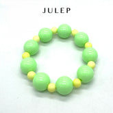 Green and yellow beaded bracelet on a white background with &