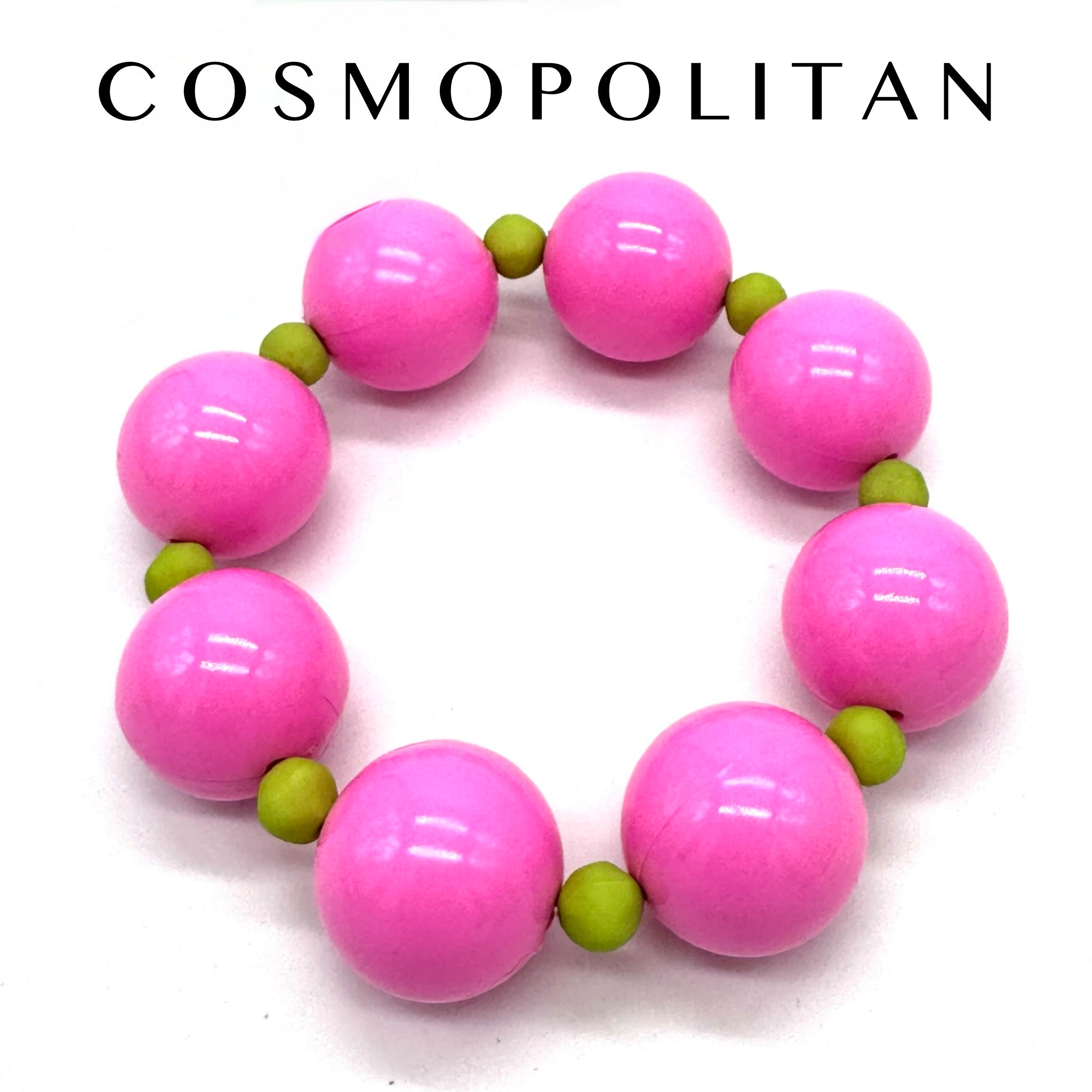 Pink and green beaded bracelet on a white background with &