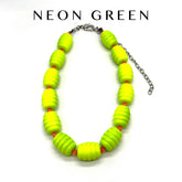 Neon green beaded necklace on a white background with &