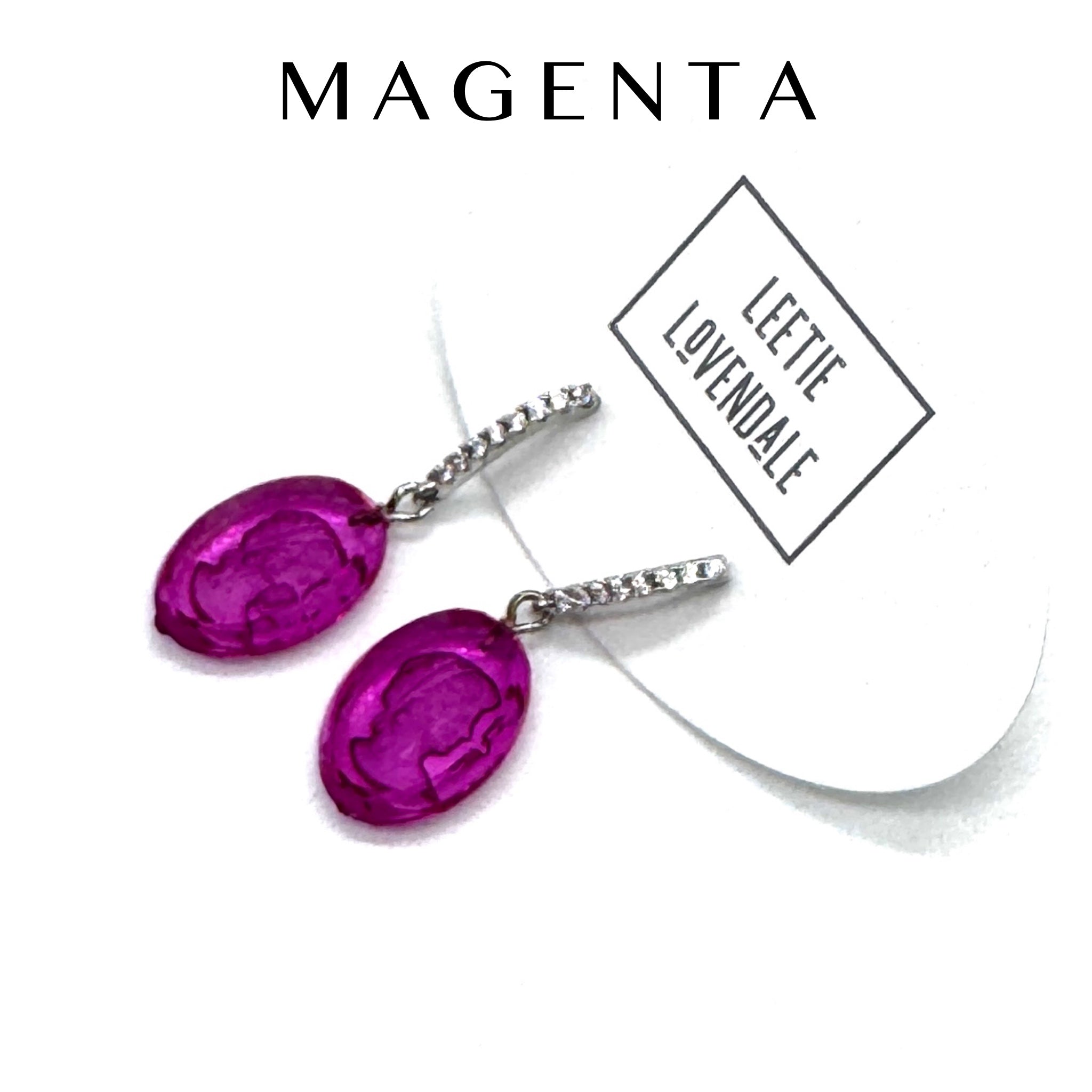 Magenta earrings with silver hooks on a white background, featuring the brand &