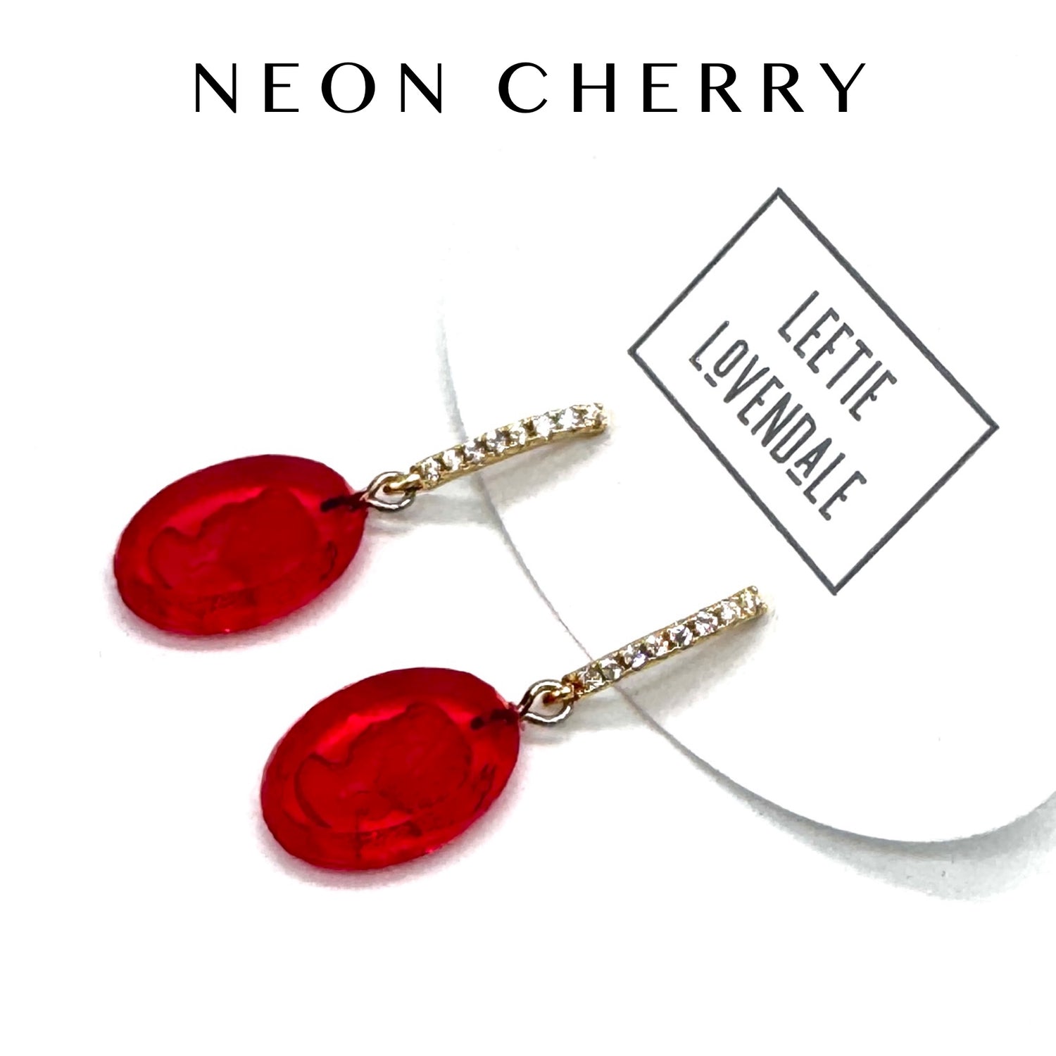 Red earrings with gold chains on a white background, branded &