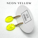 Neon yellow earrings on a white card with &