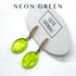 Neon green earrings on a white card with &