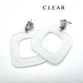 Two chunky square drop earrings made of clear frosted lucite, shown on a plain white background with the word &