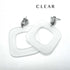 Two chunky square drop earrings made of clear frosted lucite, shown on a plain white background with the word &