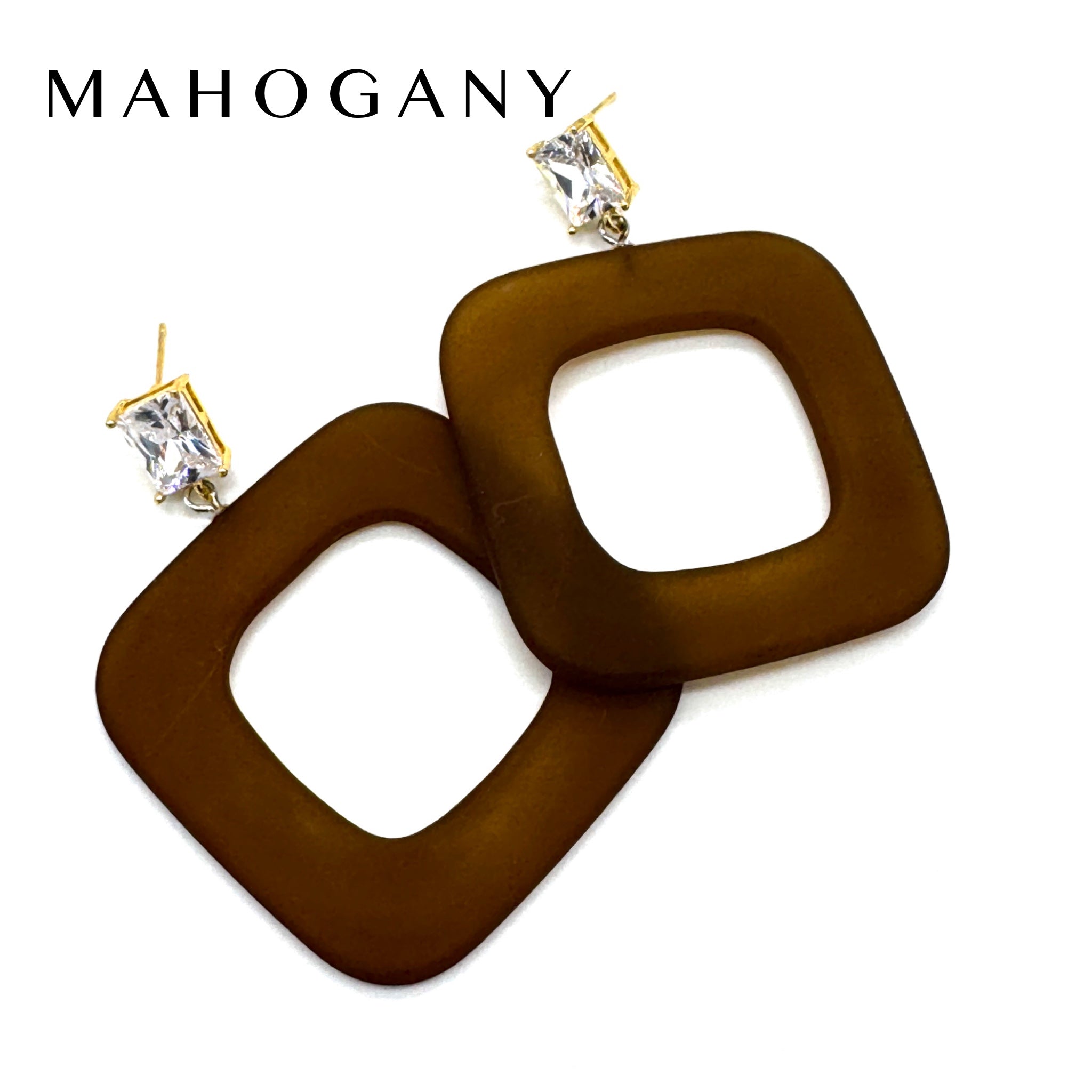 A pair of Mahogany statement earrings featuring large, square-shaped brown translucent discs with gold post and clear rhinestone studs, shown on a white background with the brand name &