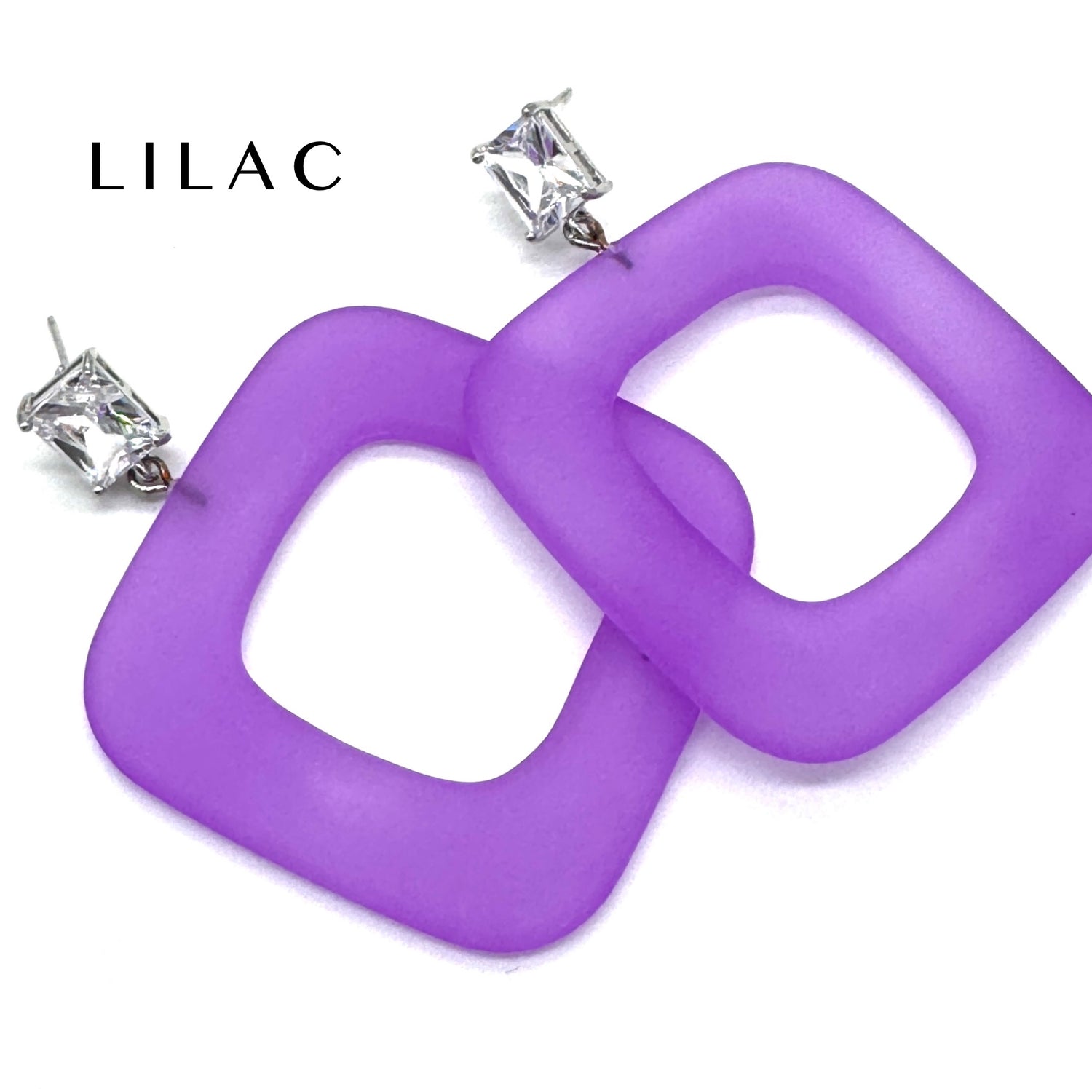 Purple square ring dangle earrings with silver post backs and clear rhinestones, shown on a white background with the brand name &