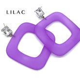 Purple square ring dangle earrings with silver post backs and clear rhinestones, shown on a white background with the brand name &