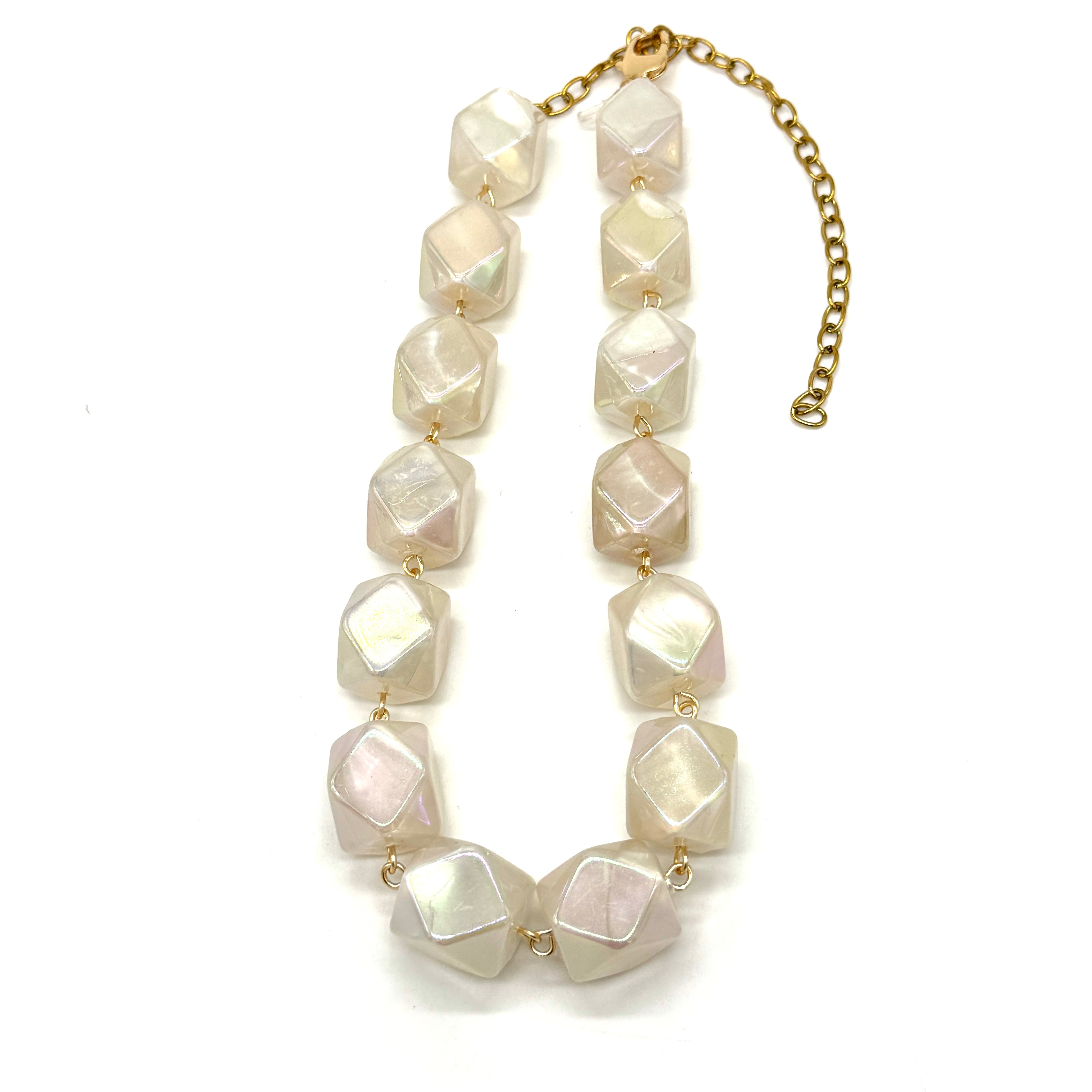 Necklace with large white beads on a gold chain against a white background