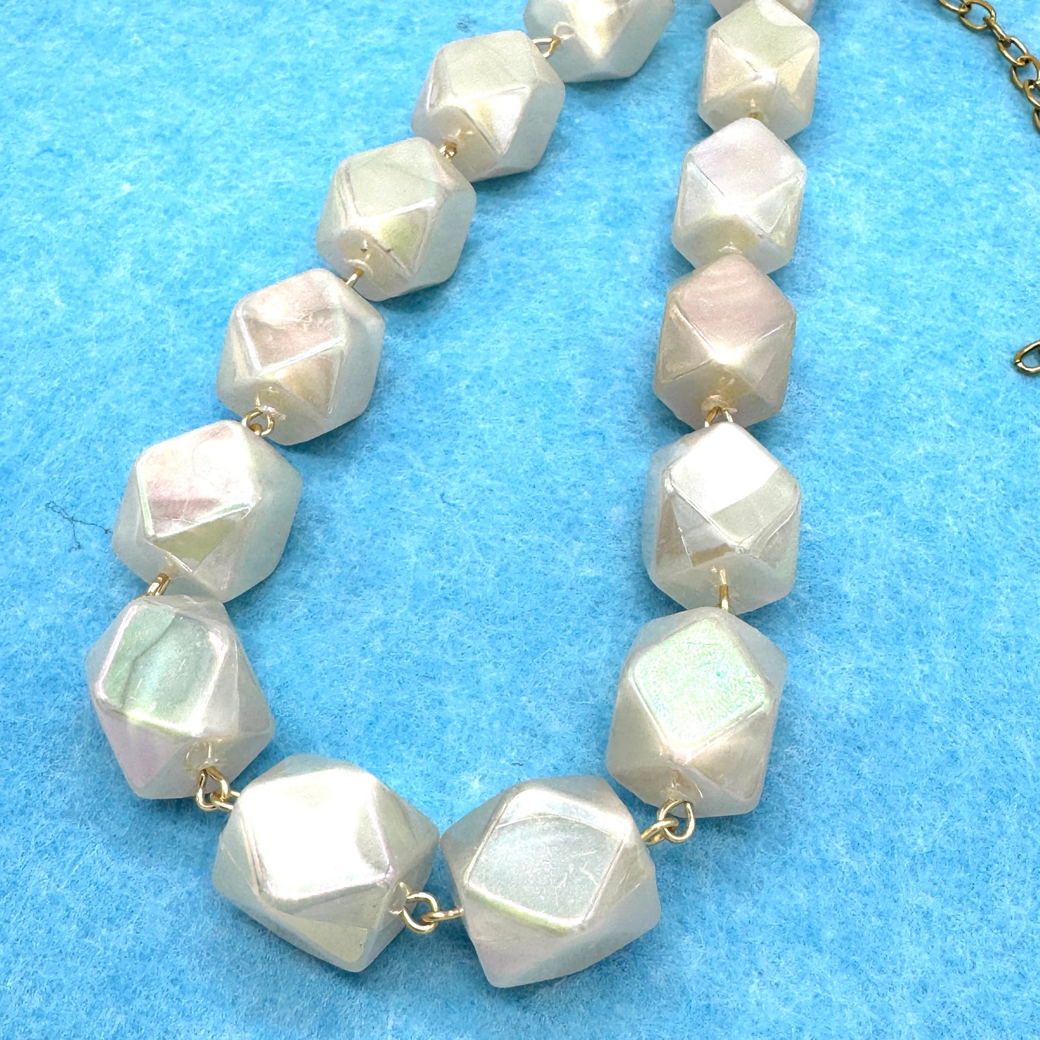 Necklace with large faceted beads on a blue background