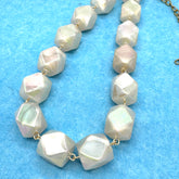 Necklace with large faceted beads on a blue background
