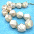 Necklace with faceted white beads on a blue background