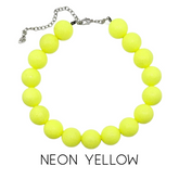 Neon yellow bead necklace on a white background