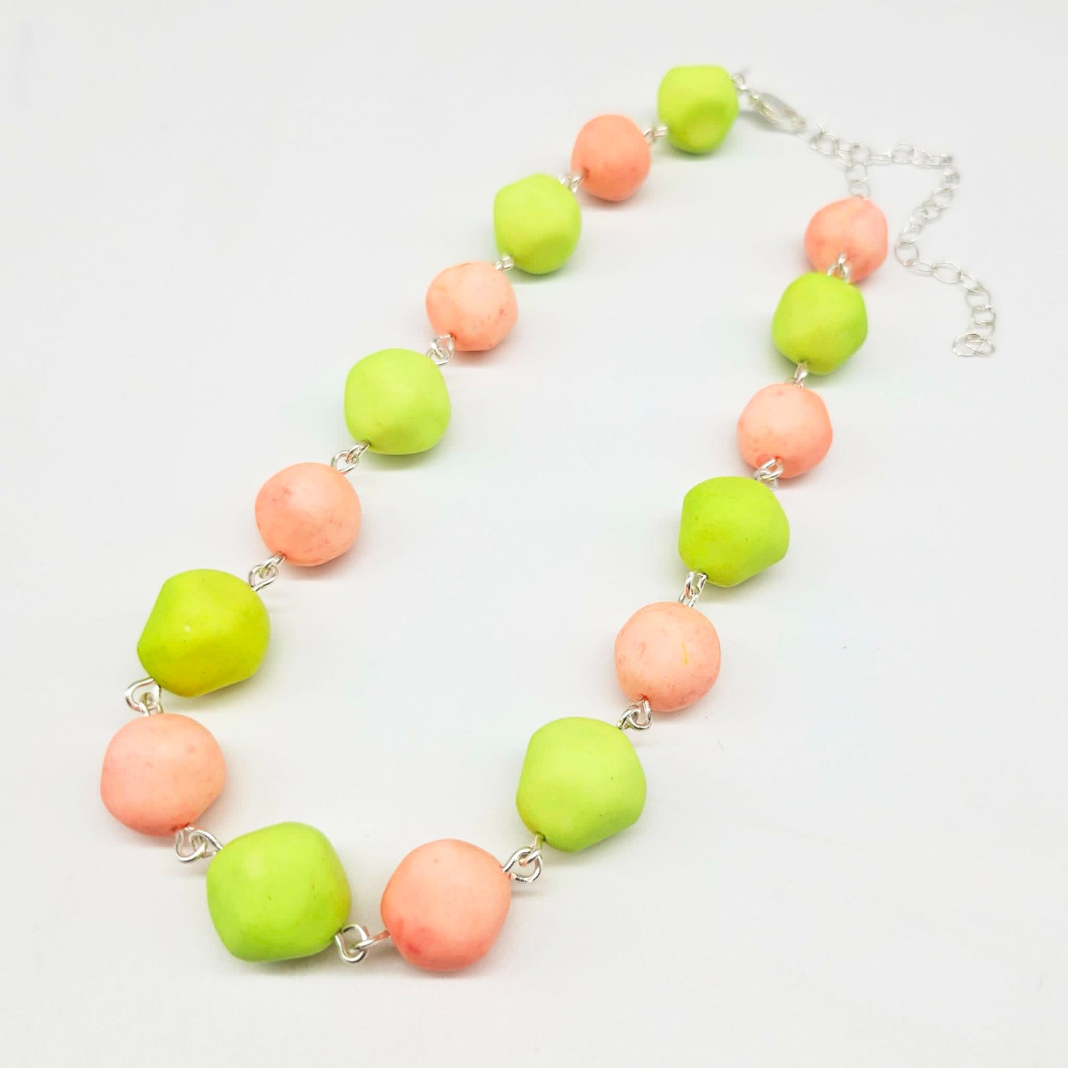 Peach and lime green beaded necklace on a white background.
