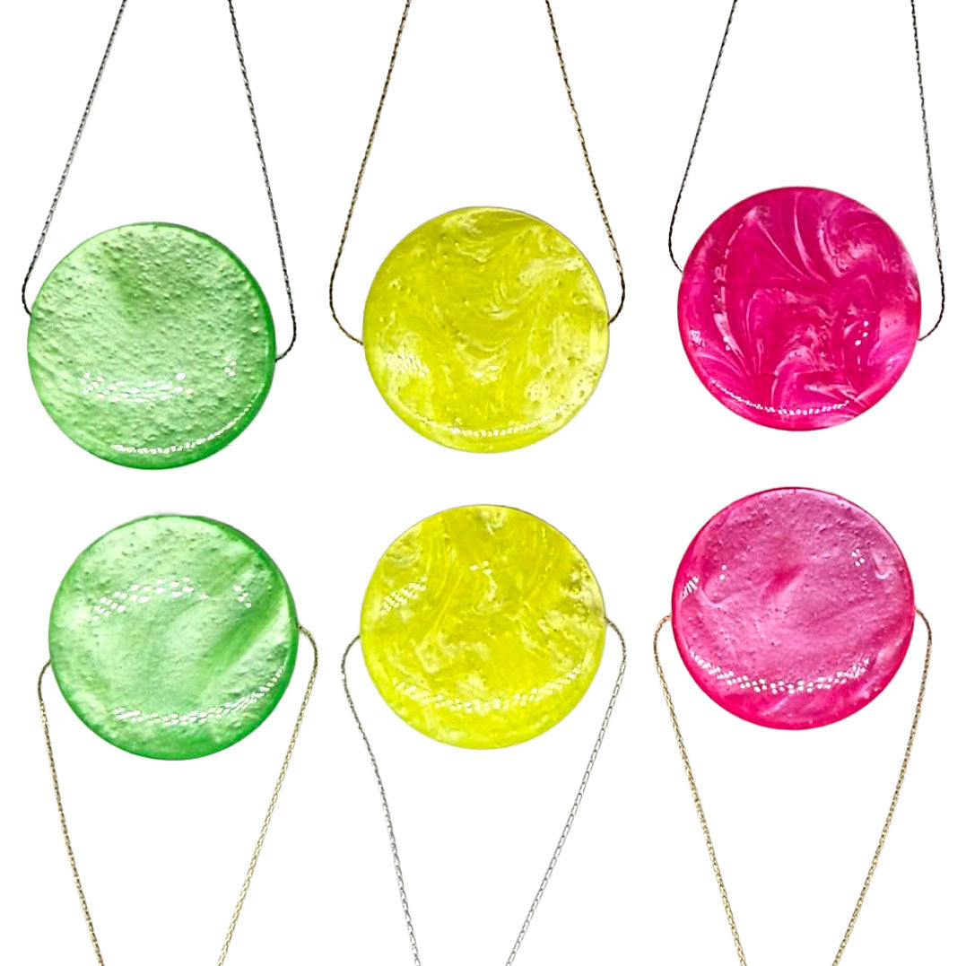 Set of six round, marbled pendant necklaces in green, yellow, and pink on a white background.