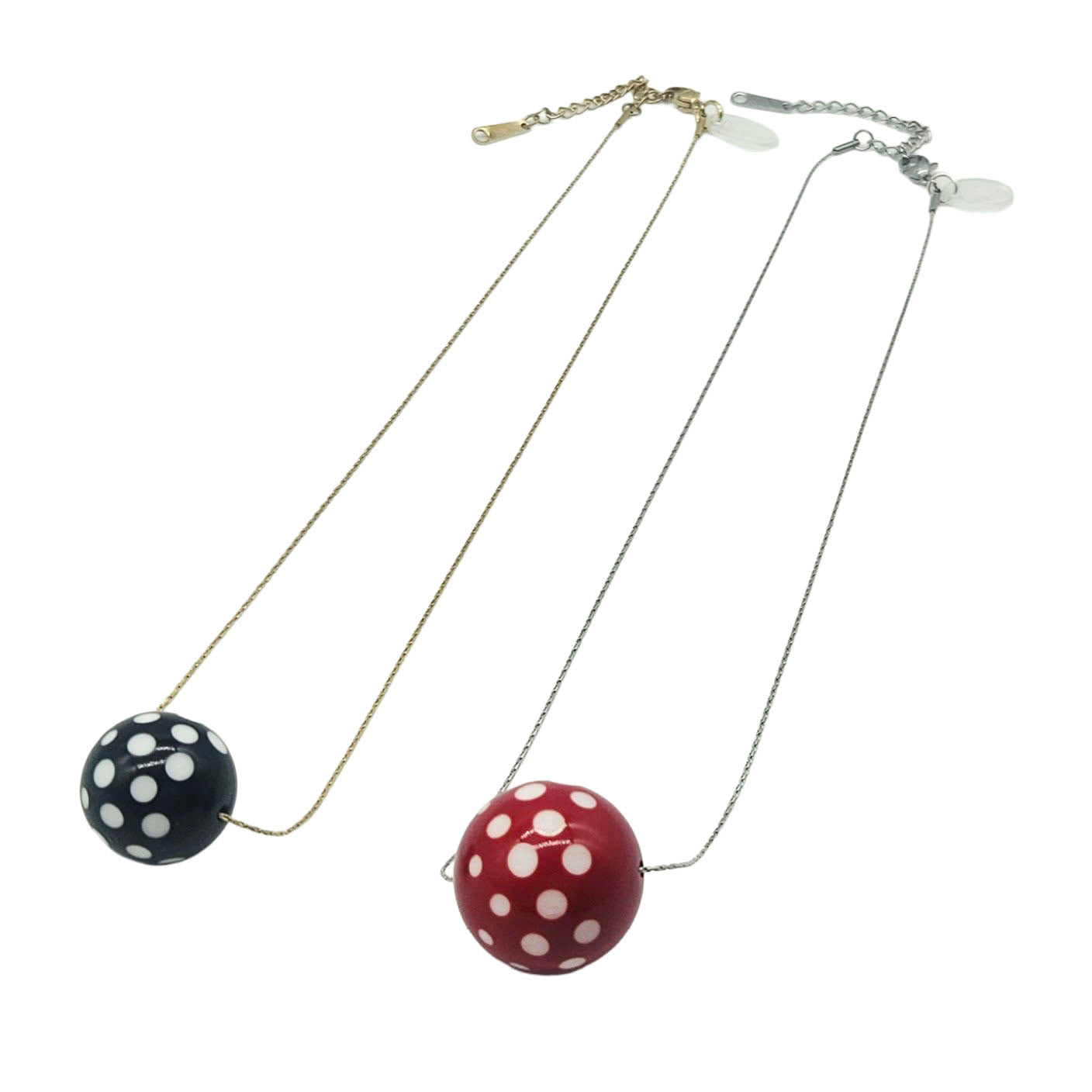 Two necklaces with polka dot pendants on a white background