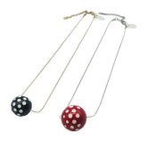 Two necklaces with polka dot pendants on a white background