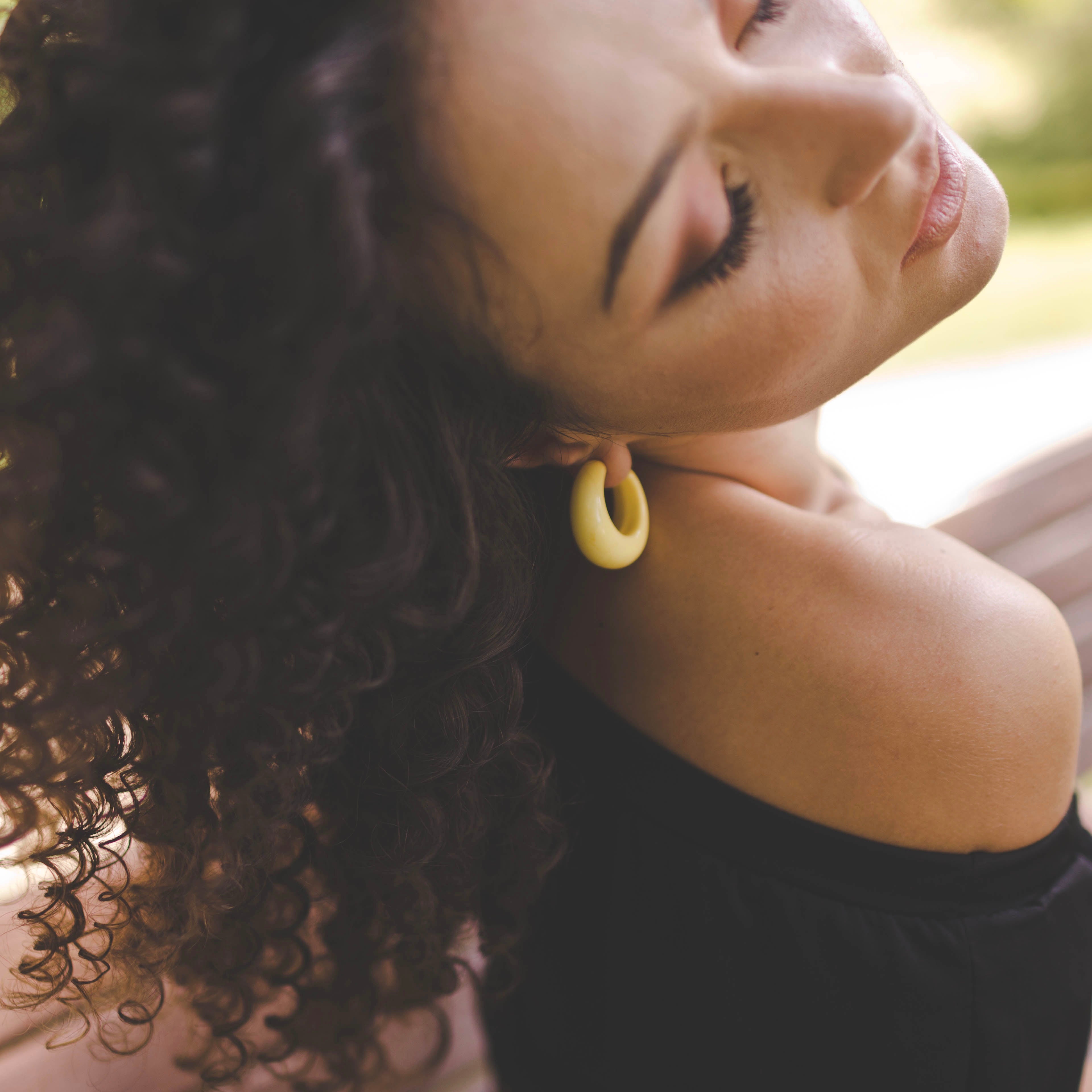 woman wearing lucille hoops with curly hair