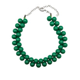Opaque green beaded necklace on a white background.