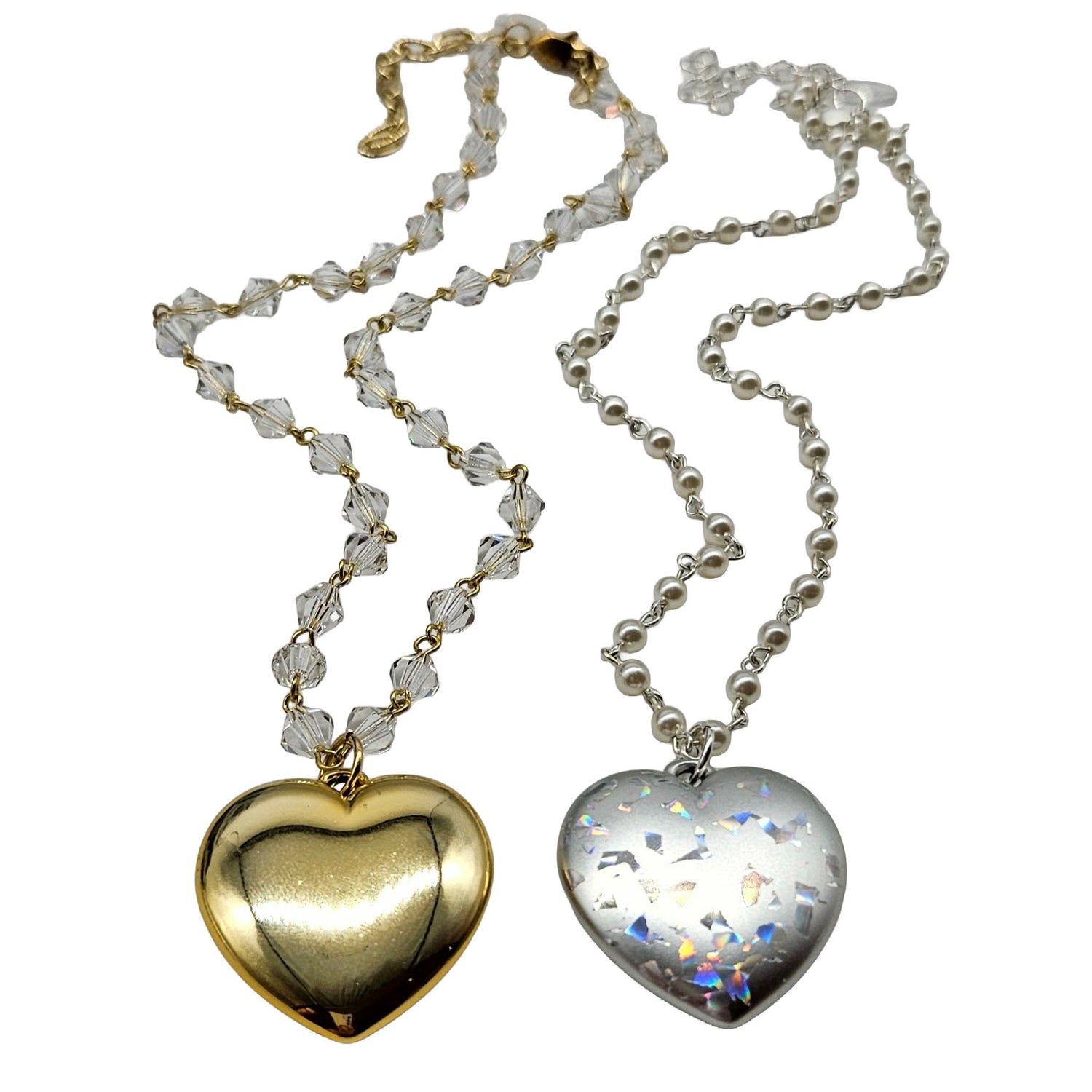 Two heart-shaped pendants on chains against a white background
