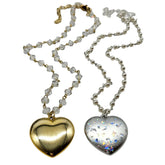 Two heart-shaped pendants on chains against a white background