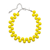 Yellow cluster beaded necklace on a white background.