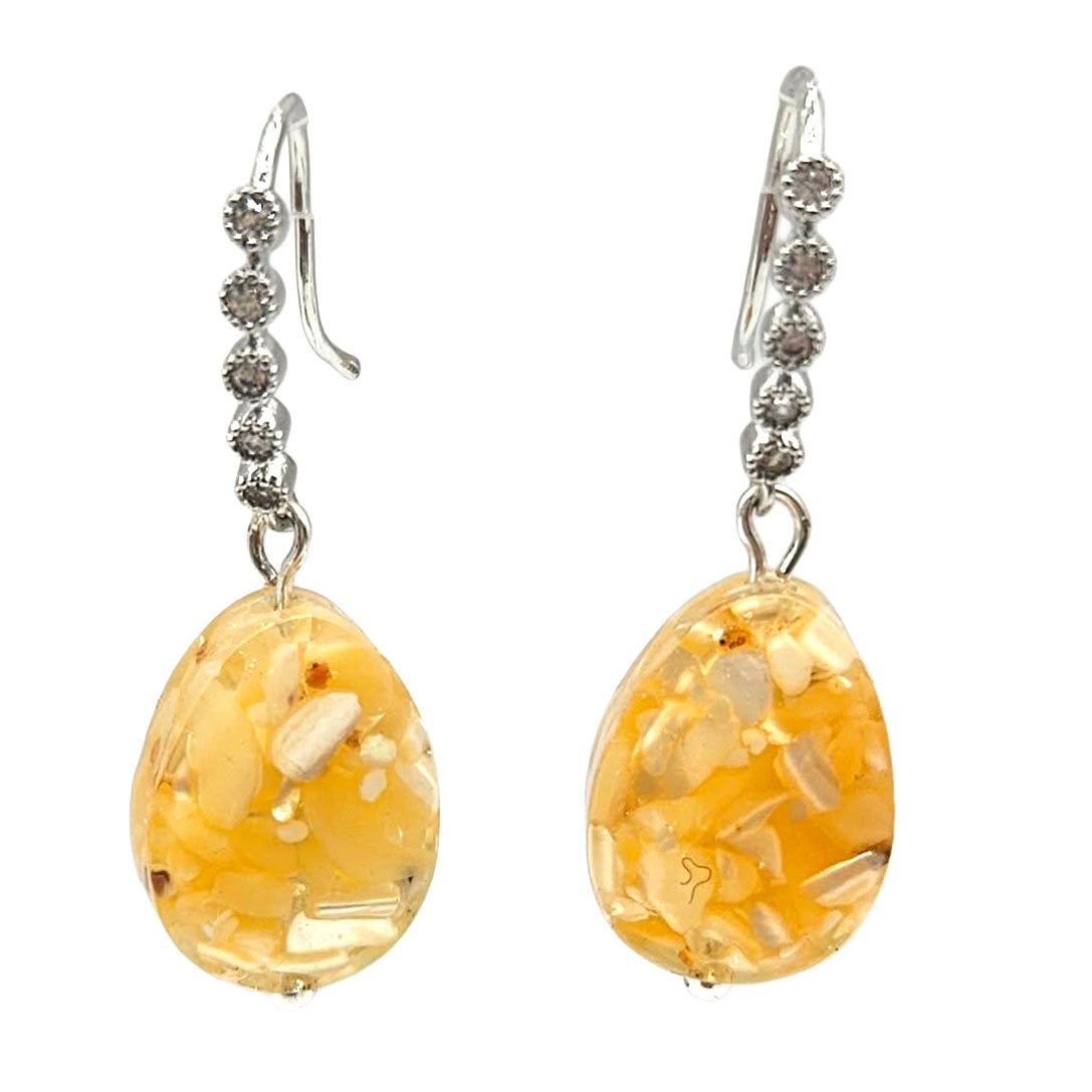 Pair of amber-colored earrings with silver hooks on a white background